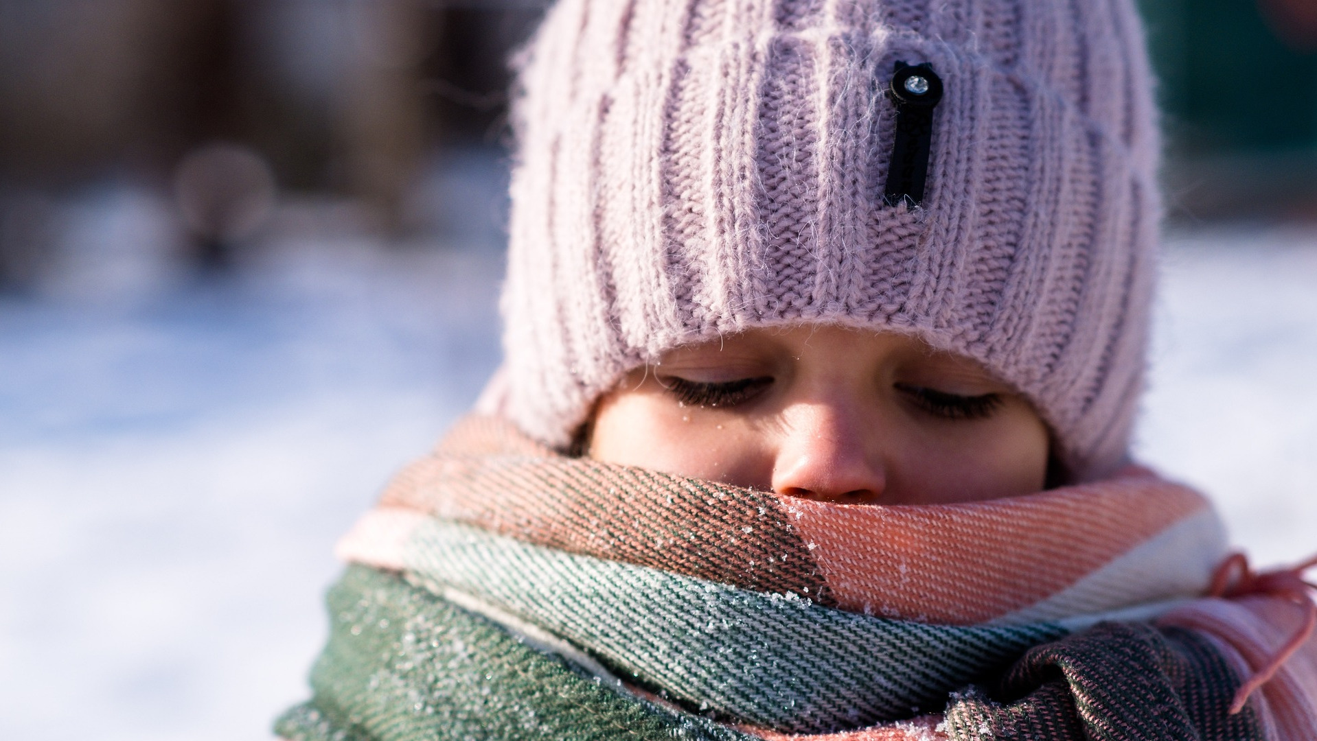 Child in the cold with a scarf around her mouth